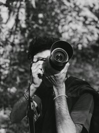 Man photographing against trees