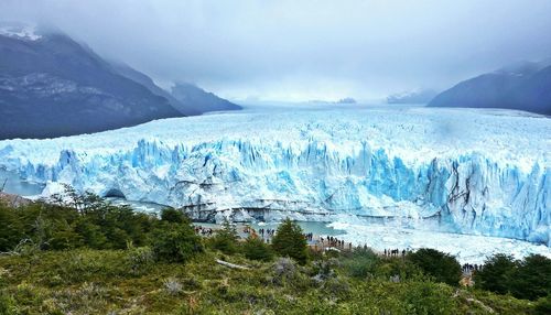 Scenic view of perito moreno glacier and mountain against cloudy sky