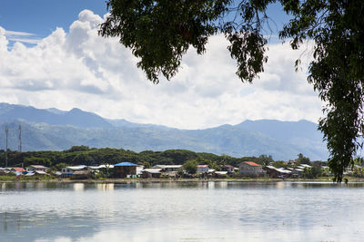 Scenic view of lake by buildings against sky