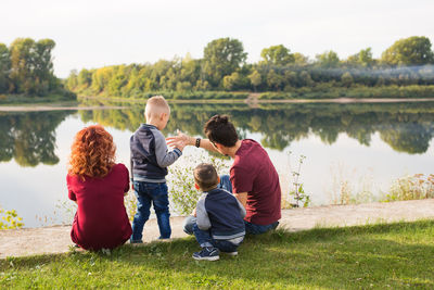 Rear view of father and son in lake