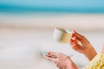 Midsection of woman holding coffee cup