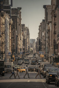 Vehicles on city street against clear sky