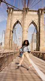 Full length of woman on footbridge in city