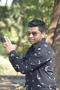 Portrait of young man wearing sunglasses standing outdoors