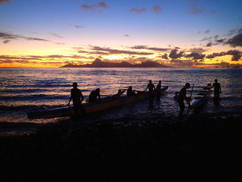 SILHOUETTE OF PEOPLE ON BEACH AT SUNSET