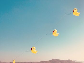 Low angle view of kite flying against clear blue sky