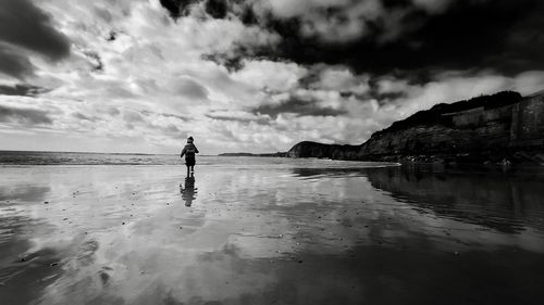 Man standing on beach against sky