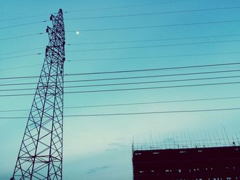 Low angle view of electricity pylon against clear sky