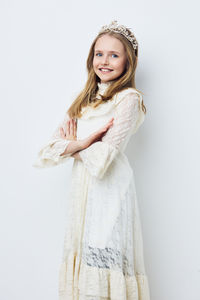 Portrait of young woman standing against white background