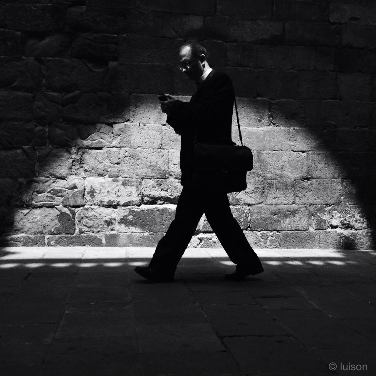 full length, lifestyles, street, rear view, walking, cobblestone, shadow, architecture, built structure, leisure activity, men, standing, sunlight, night, sidewalk, building exterior, brick wall, silhouette