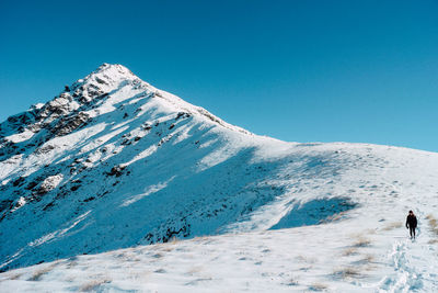 Scenic view of snow covered mountains against clear sky