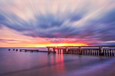 View of calm sea against cloudy sky during sunset