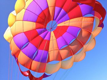Low angle view of multi colored parachute against clear sky