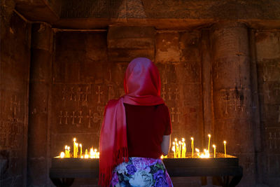 Rear view of woman praying in church