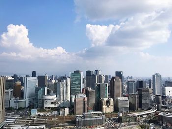 Aerial view of buildings in city against sky