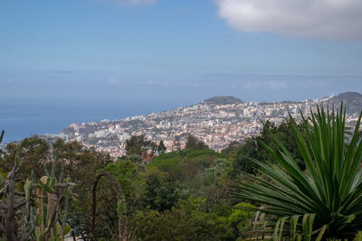 Scenic view of sea by buildings against sky