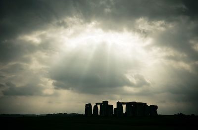 Silhouette of building against cloudy sky