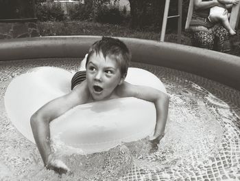 Happy boy on inflatable ring floating in wading pool