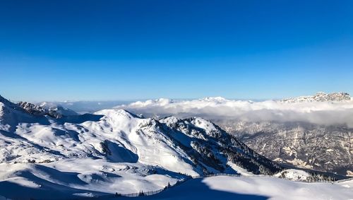 Scenic view of snowcapped mountains against blue sky