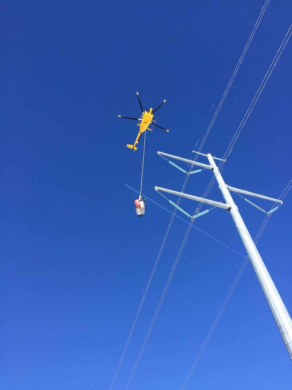 LOW ANGLE VIEW OF HELICOPTER AGAINST CLEAR BLUE SKY