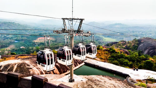 Overhead cable car on mountains against sky