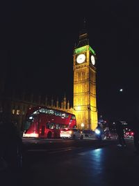 Illuminated clock tower at night