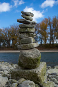 Stack of stones on rock against sky