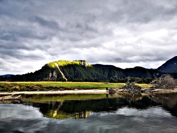 Scenic view of lake by mountain against sky