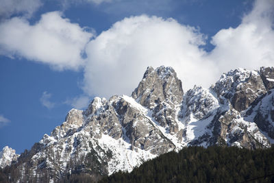 Low angle view of snowcapped mountains against sky