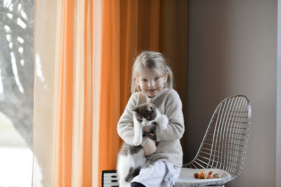 A cute little girl playing with a cat at home
