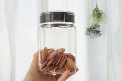 Midsection of person holding glass jar