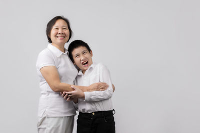 Happy friends standing against white background