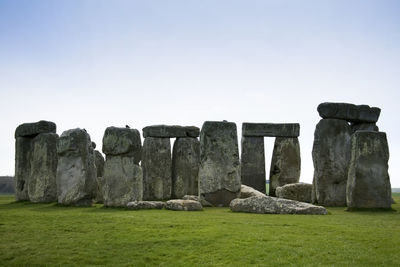 Stone wall on field against clear sky