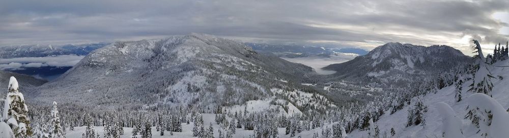 Snow covered mountains against cloudy sky