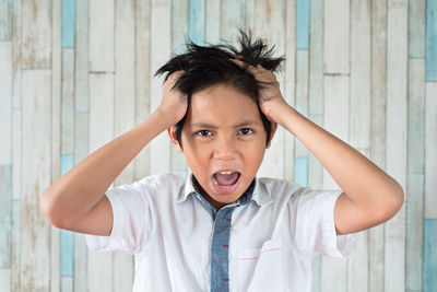 Boy screaming against wall