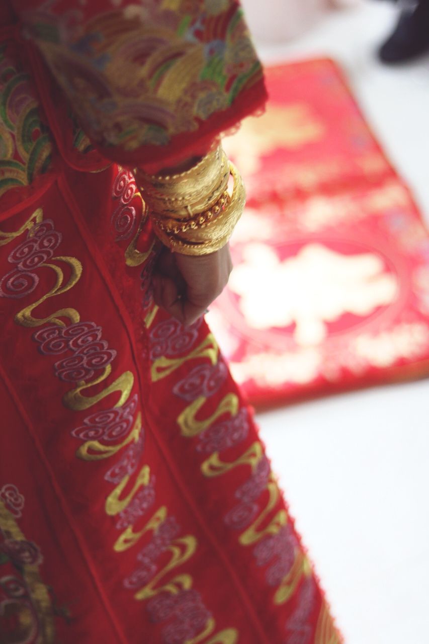 cultures, red, celebration, real people, one person, close-up, sari, bangle, indoors, day, people, human hand, human body part, adult