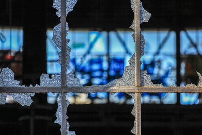 Close-up of fence against building during winter