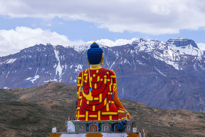 Statue of buddha against mountain range