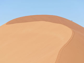 Sand dunes in desert against clear sky