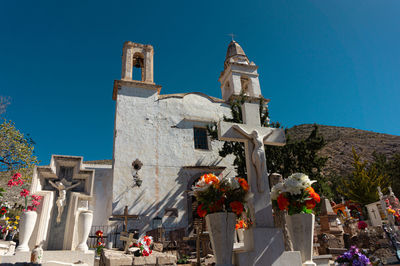 Low angle view of a white church against clear blue sky