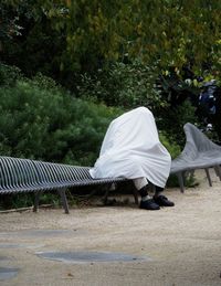 Rear view of couple sitting on bench in park