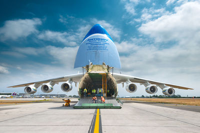 Airplane on airport runway against sky