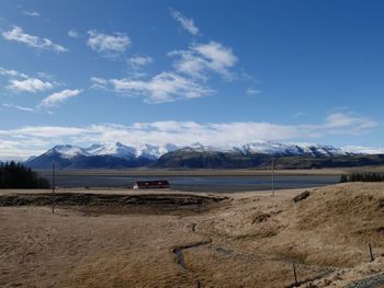 Scenic view of snowcapped mountains against blue sky