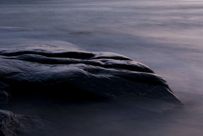 Close-up of rock formation in sea against sky