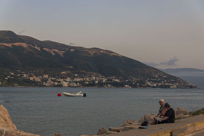 Scenic view of sea and mountains against sky