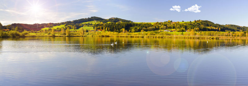 Wide angle view to alps mountain range mirroring in lake forggensee in region allgaeu in bavaria