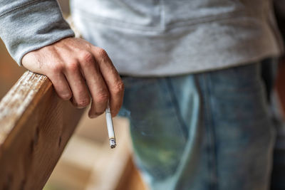 Midsection of man smoking cigarette