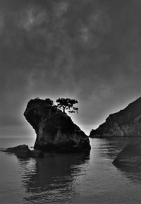 Rock formation on sea against sky