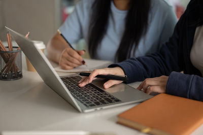 Midsection of woman using laptop on table