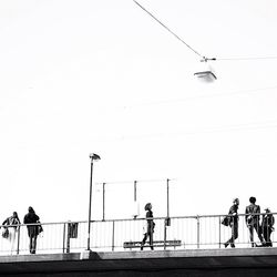 People walking on street in city against clear sky